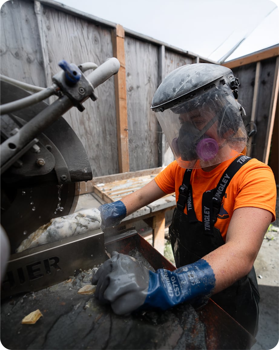 Worker using machinery with safety gear on